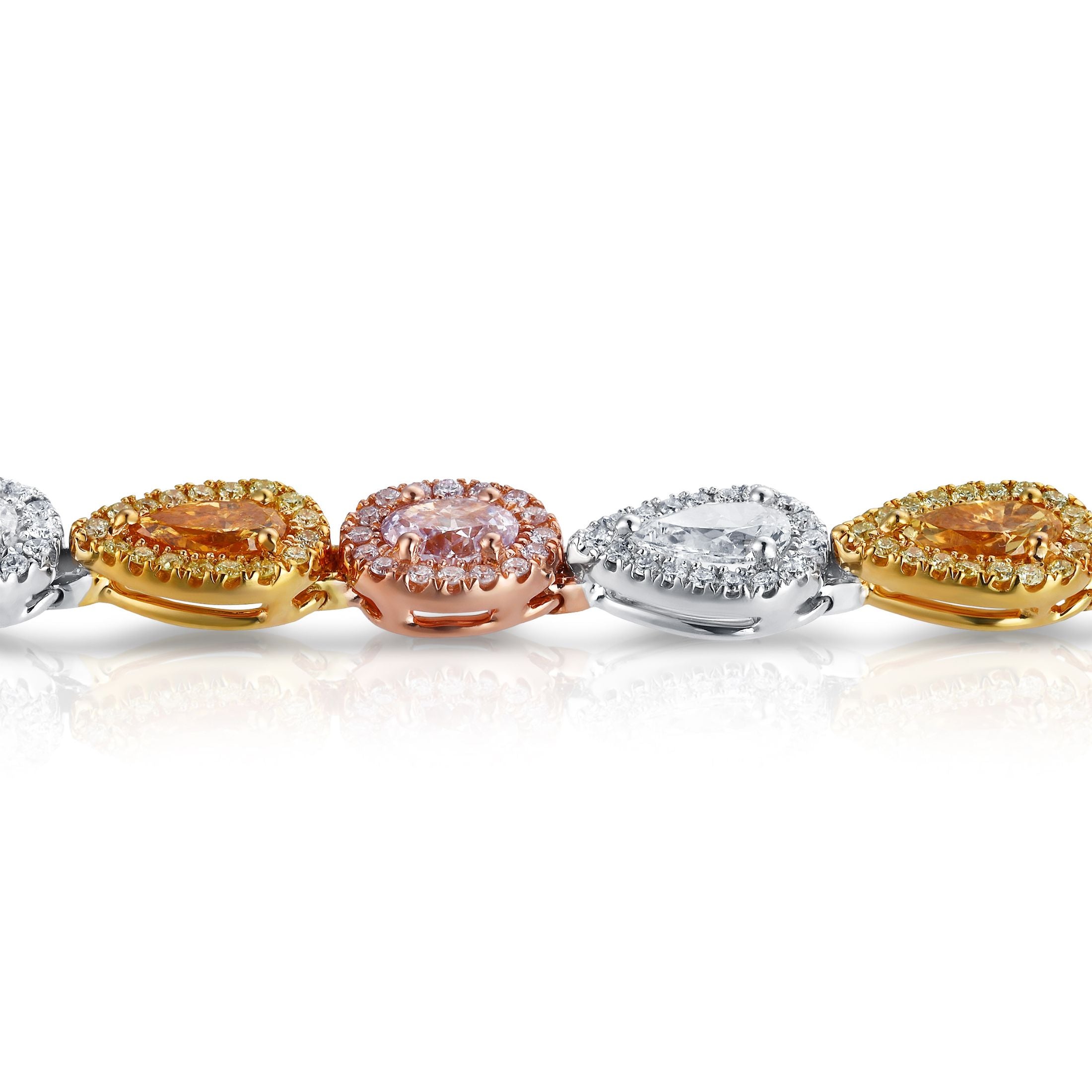 Close-up of pear and oval gemstone settings with diamond halos in mixed gold tones