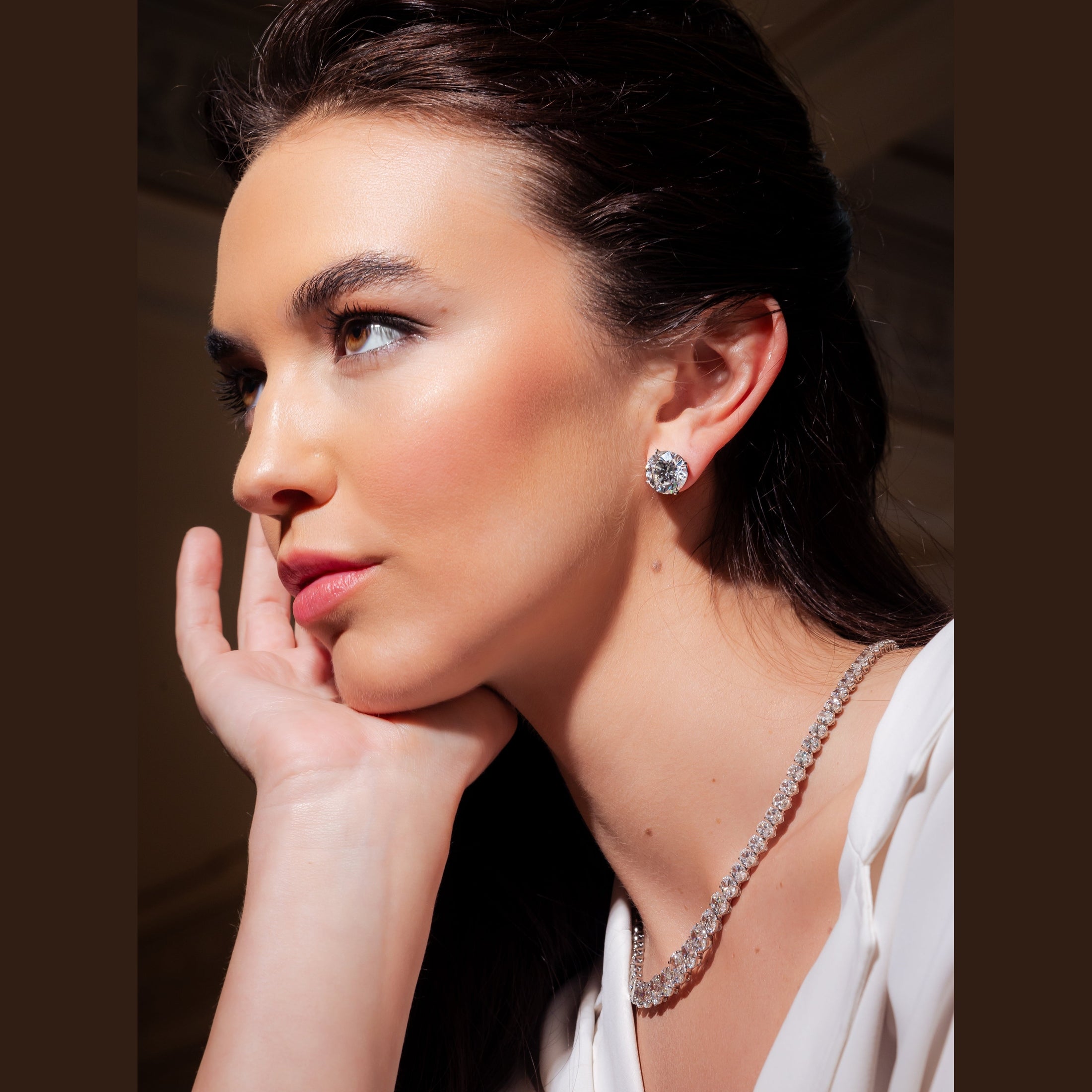 Woman wearing Leviev diamond stud earrings and matching necklace