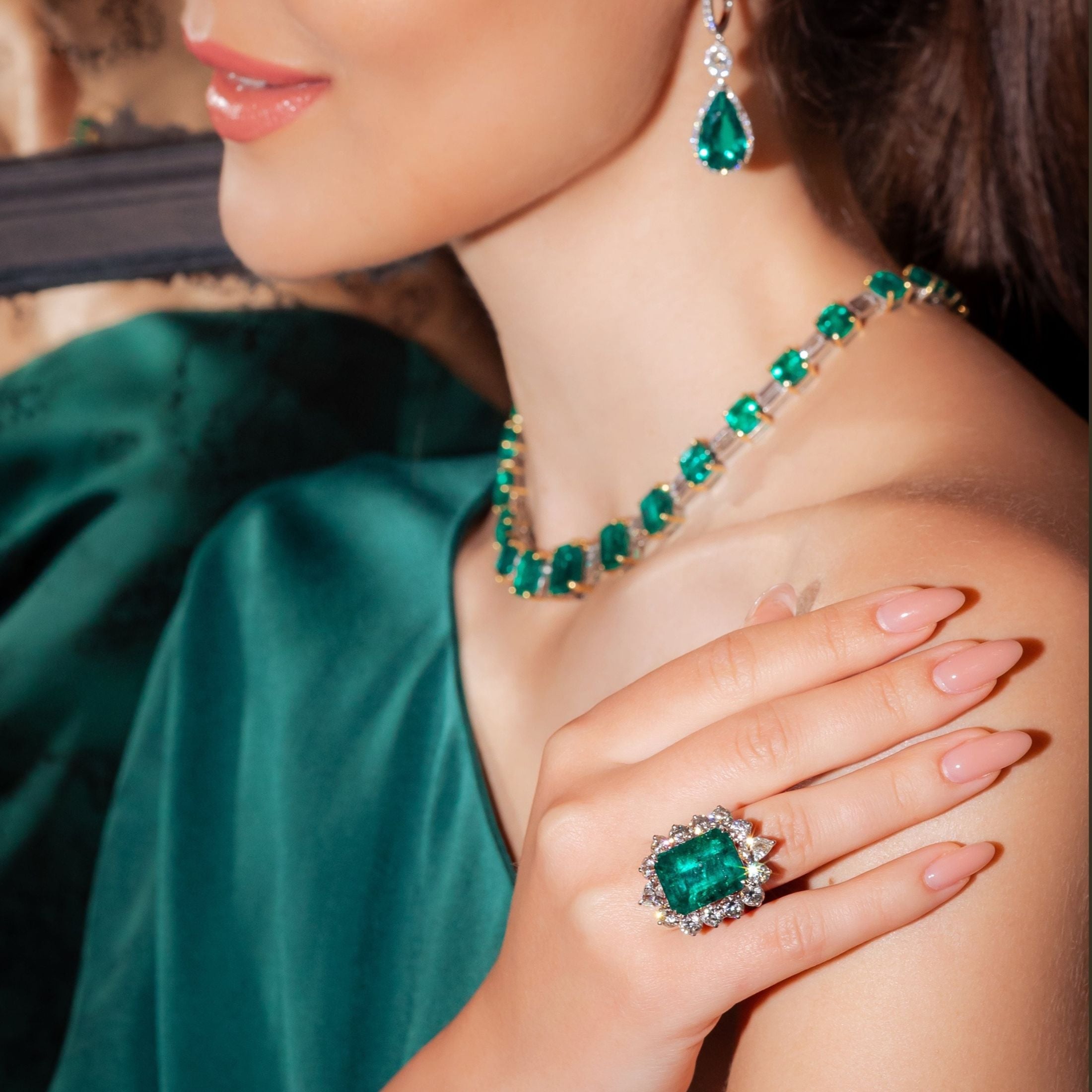 Emerald and diamond jewelry set including ring, earrings, and necklace