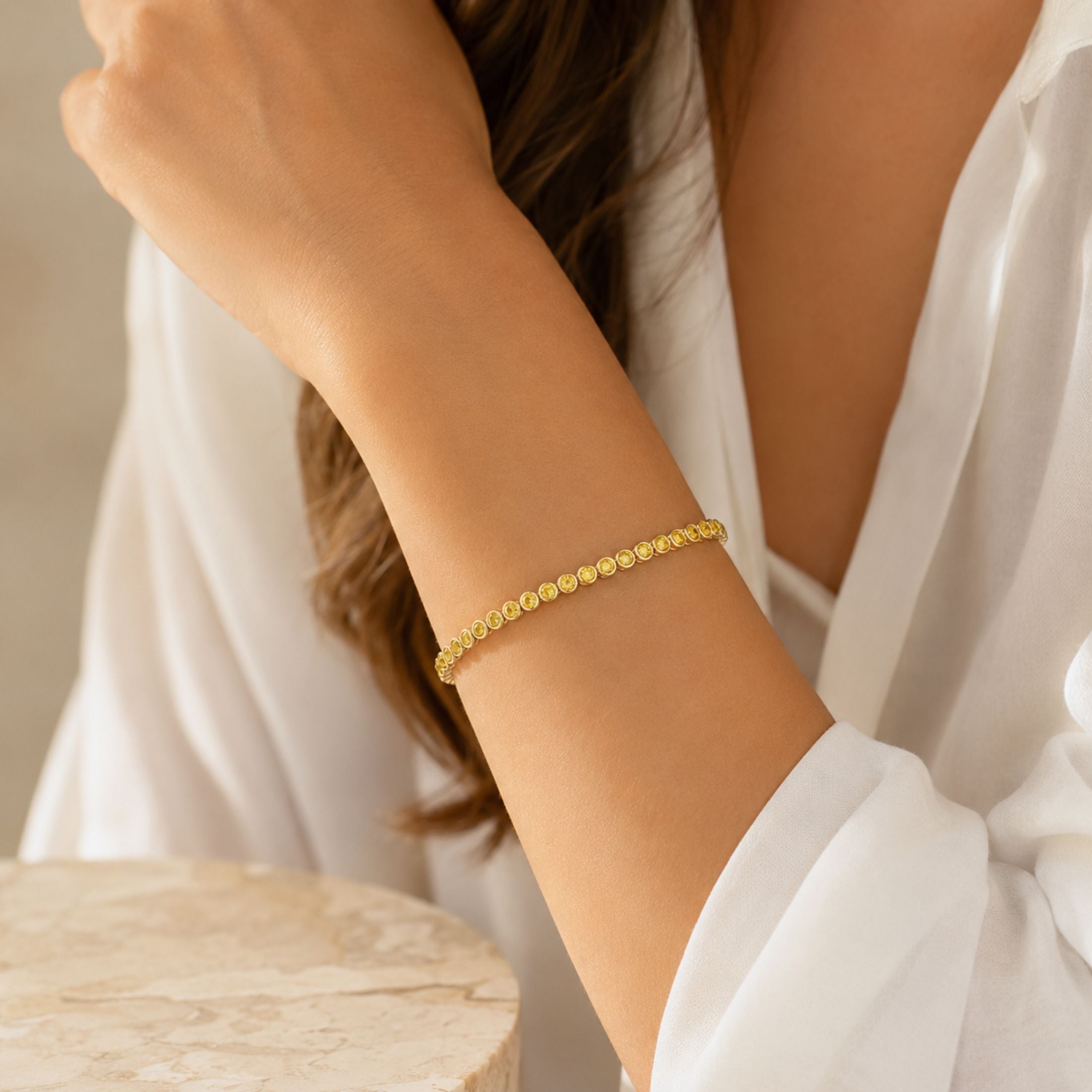 Yellow diamond tennis bracelet on wrist showing fit and drape