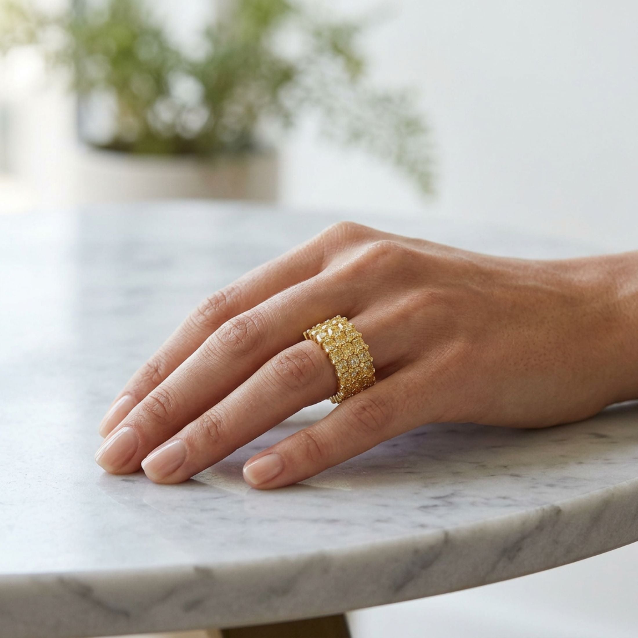 Close-up of woman's hand modeling Leviev yellow gold eternity ring with vivid yellow diamonds