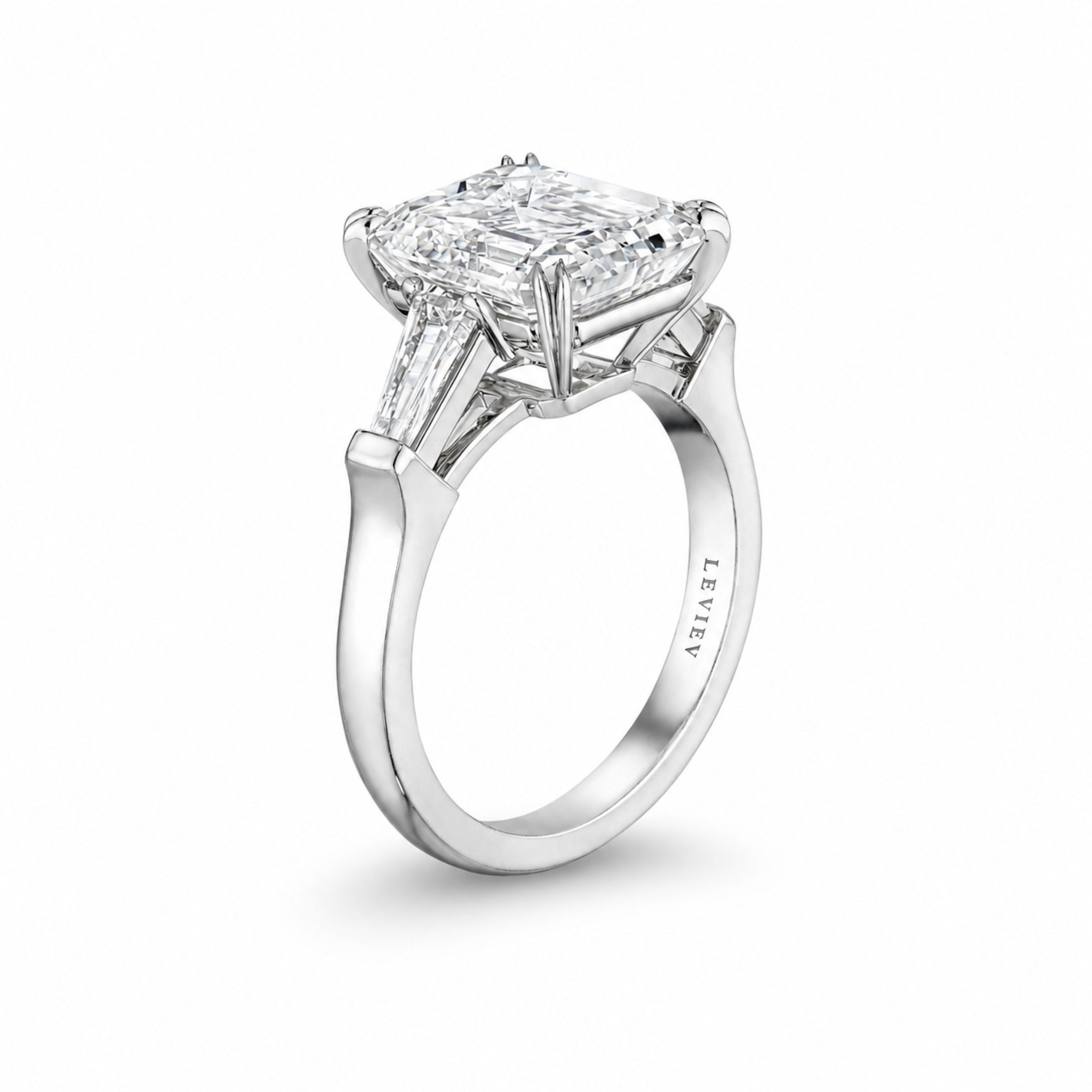 Leviev platinum three-stone diamond ring with emerald-cut center and baguette side stones, engraved band