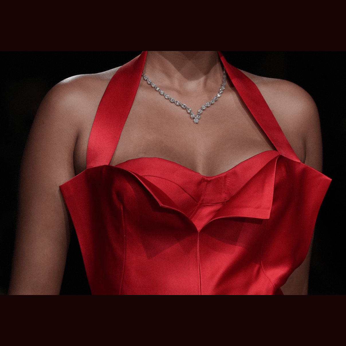 Model wearing Leviev pear diamond necklace as halter over red satin evening dress
