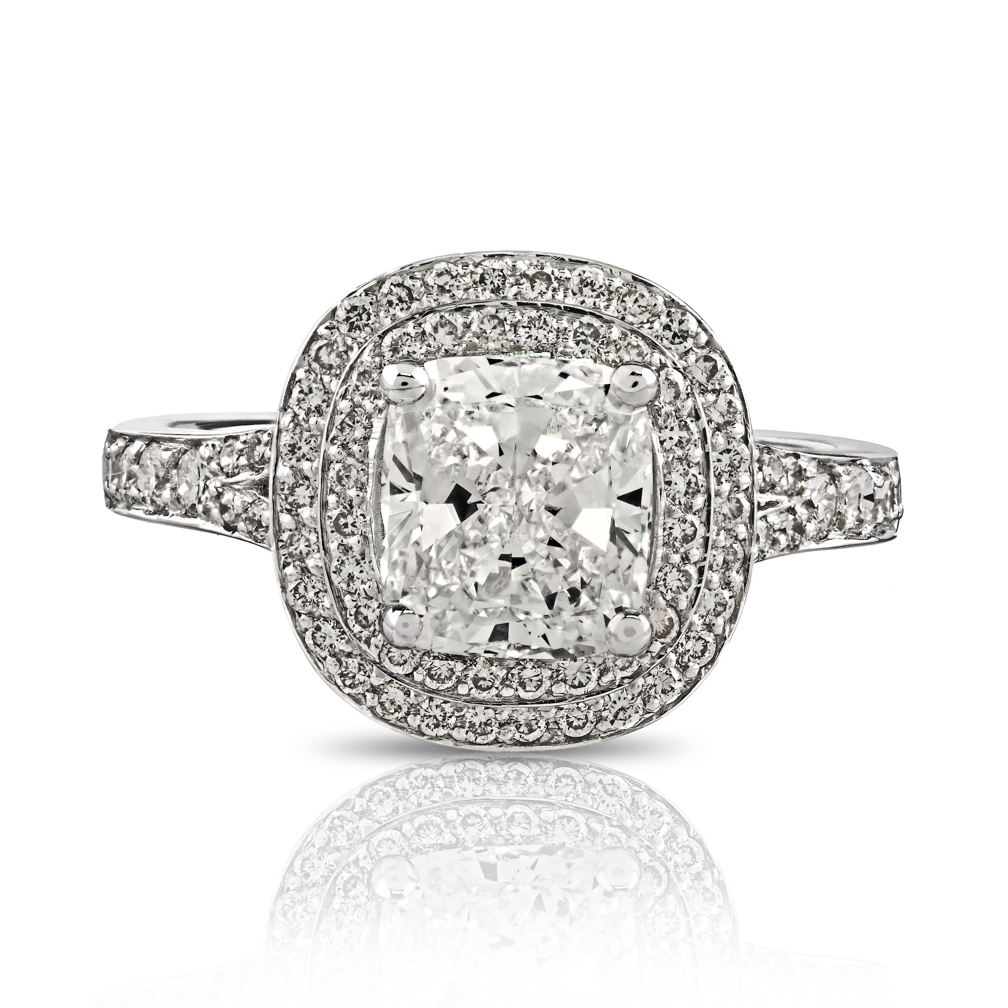 Top down view of 14K white gold cushion cut diamond engagement ring featuring double halo and pavé shoulders