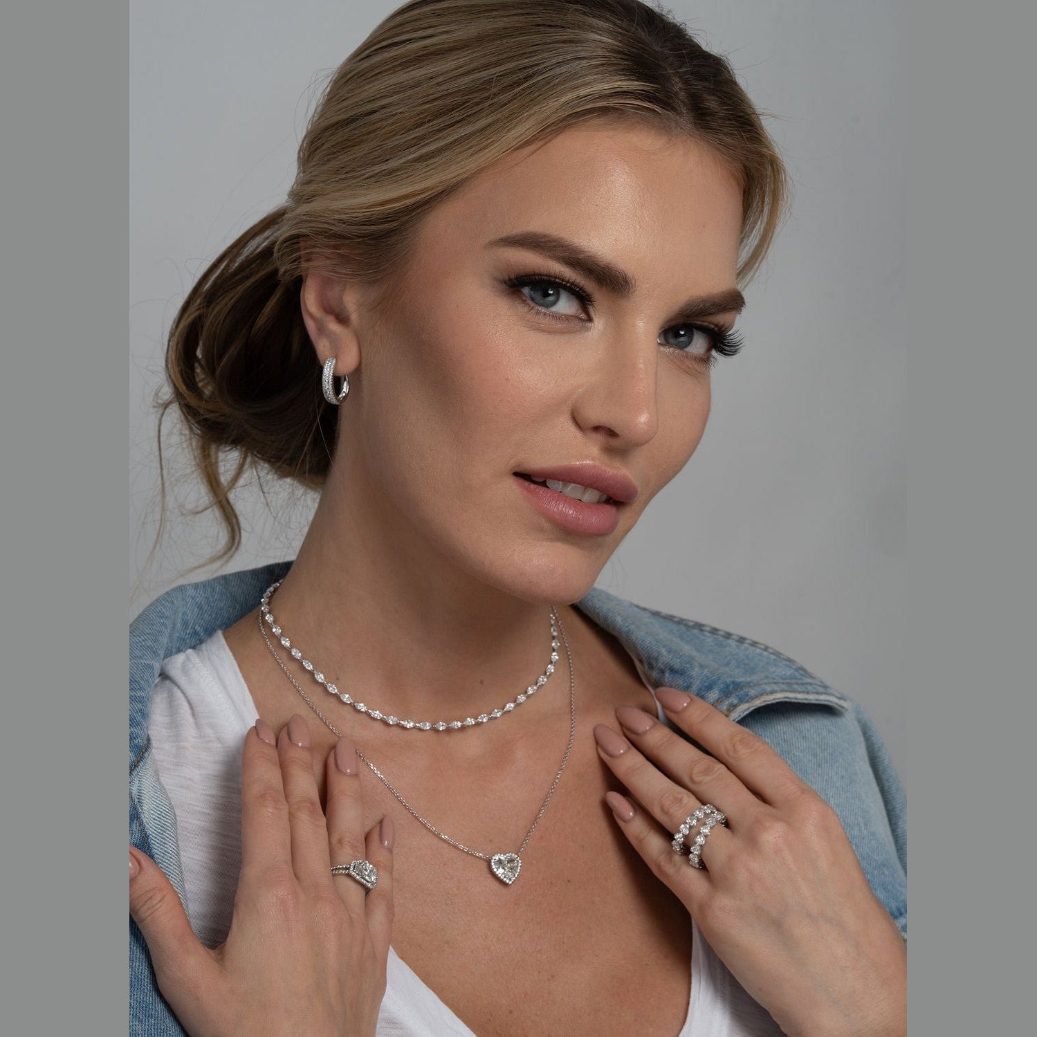 Woman wearing Leviev diamond cluster huggie hoops styled with matching necklace and ring in lifestyle shot