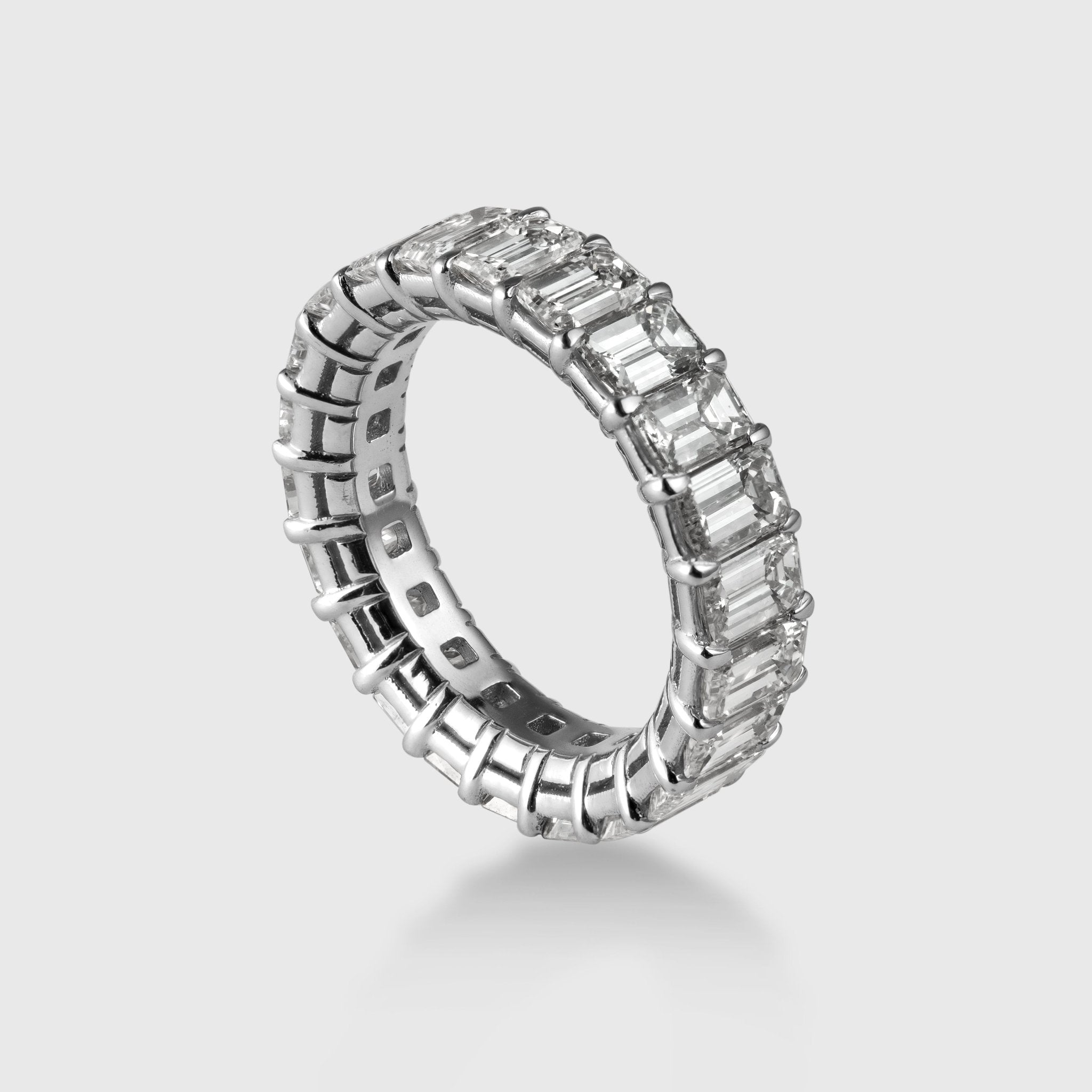 Angled shot of platinum emerald cut diamond eternity band sparkle